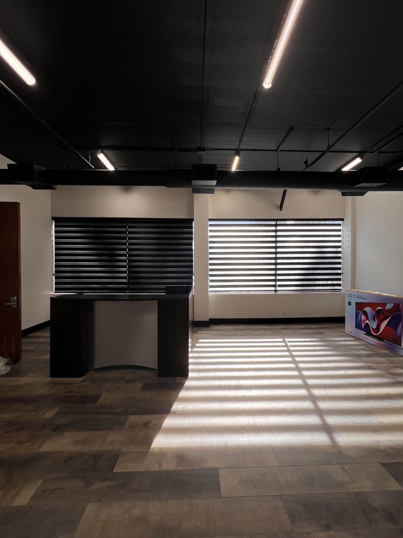 Reception area after dark with black zebra shades casting striped light across the floor