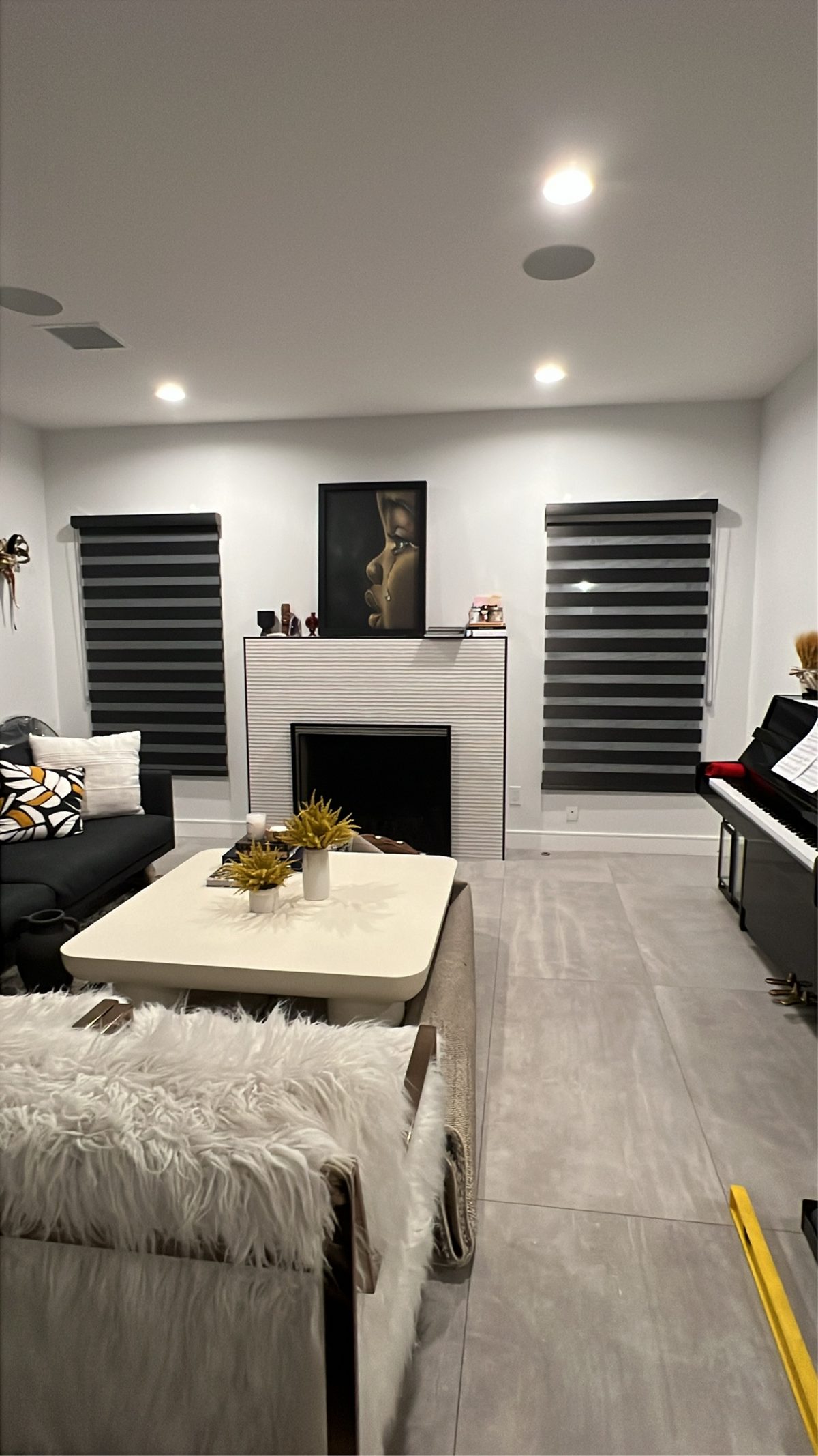 Real ShadeSpot install: black blackout zebra shades flanking a fireplace in a living room