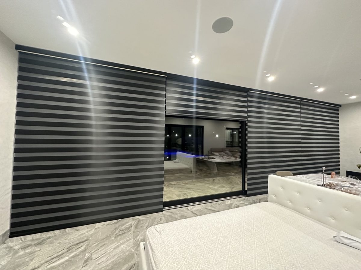 Real ShadeSpot install: black zebra shades across sliding glass doors in a modern living room
