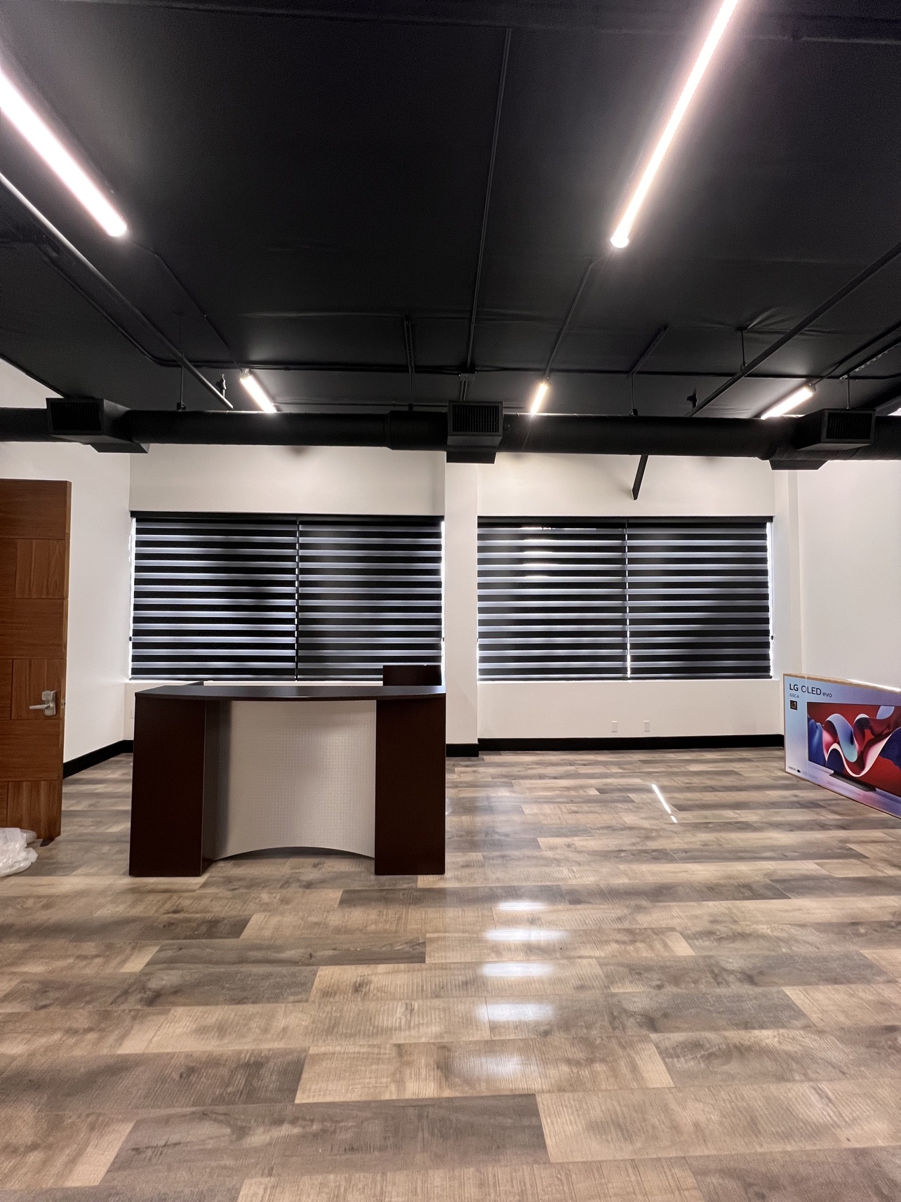 After: office reception with black zebra shades across both window walls