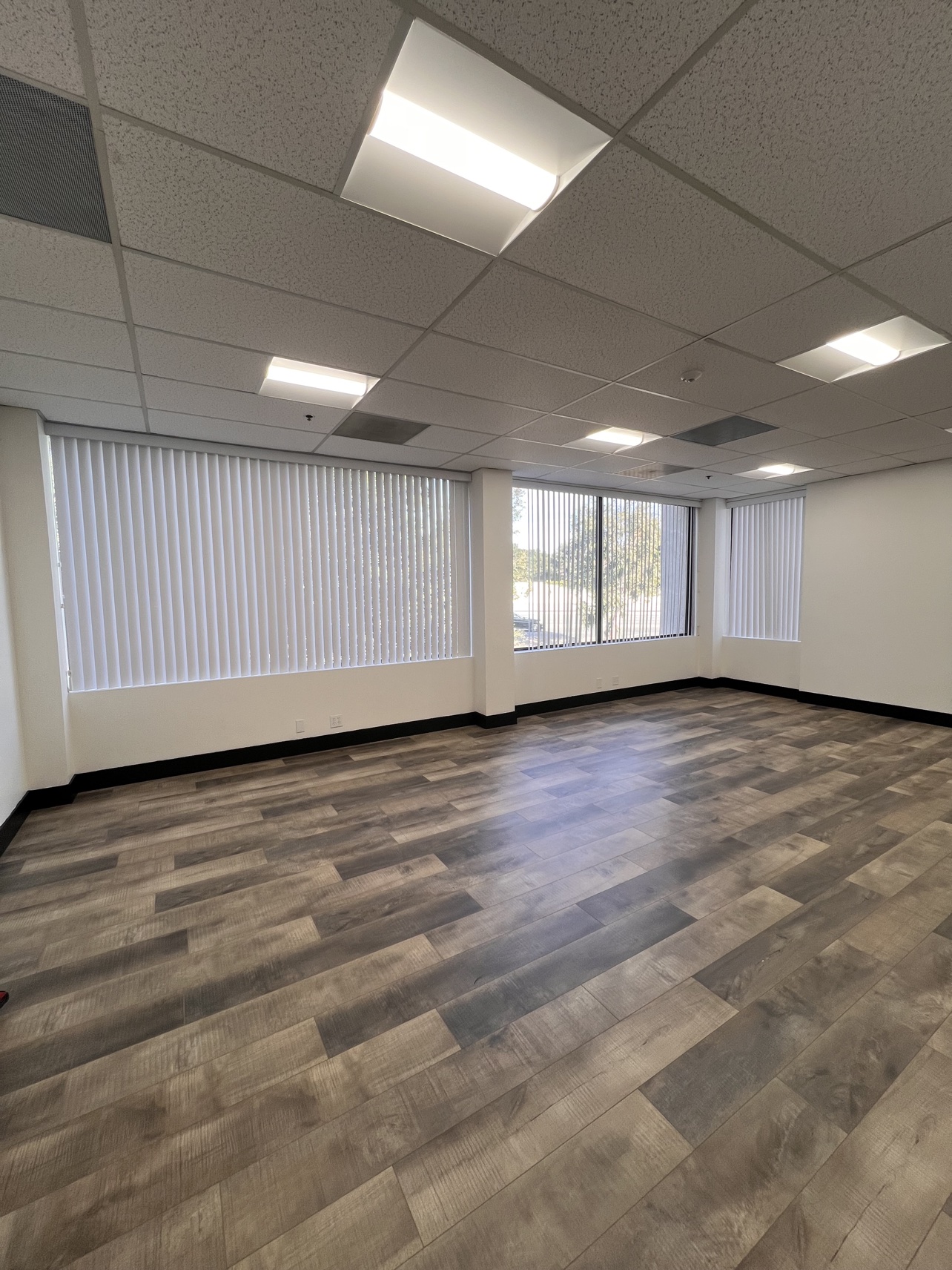 Before: the same office suite with white vertical blinds