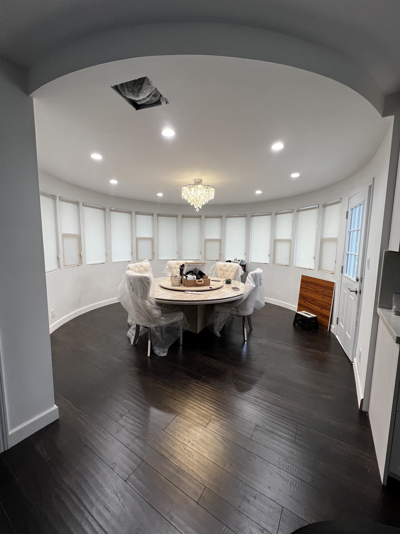 Real ShadeSpot install: white light-filtering roller shades in a curved dining room