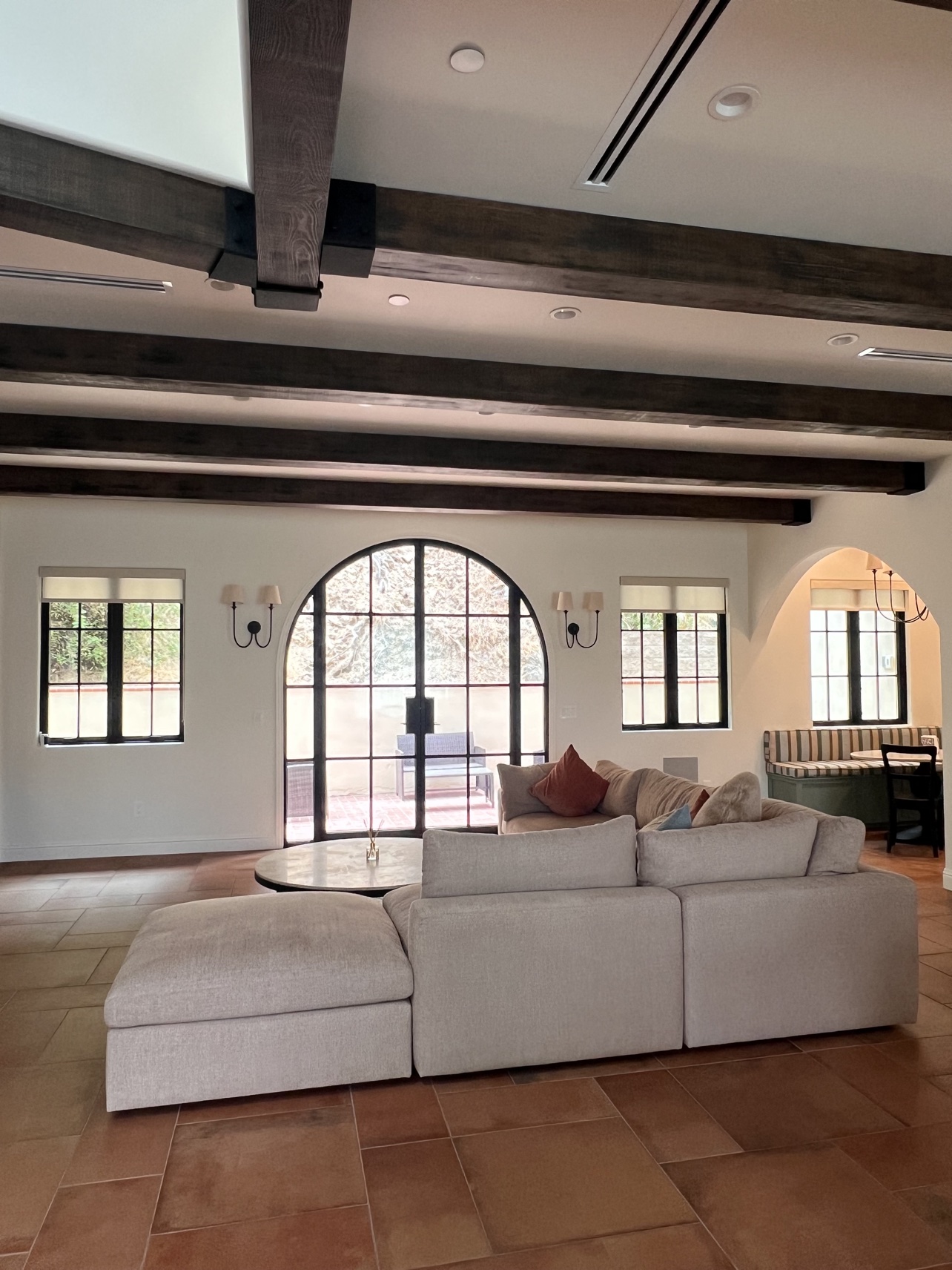 Light-filtering roller shades rolled up on black-framed windows