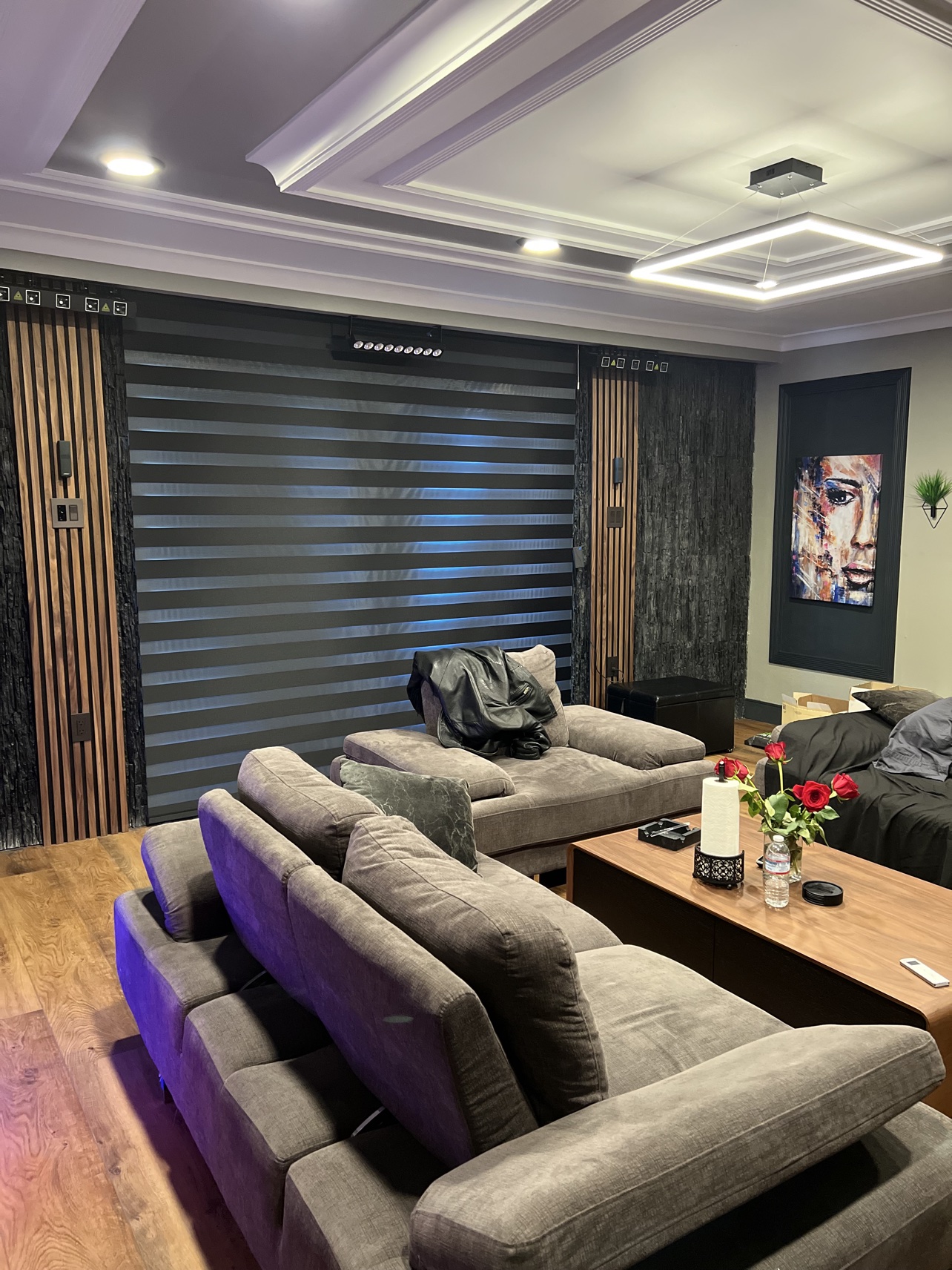 Real ShadeSpot install: black blackout zebra shades behind sofas in a media room