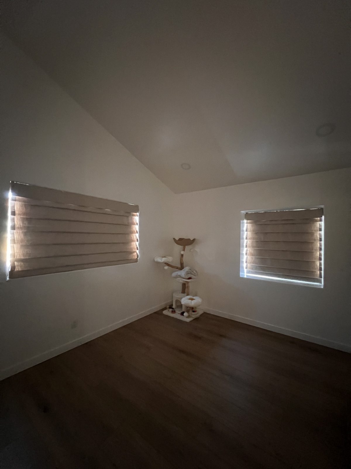 Real ShadeSpot install: the same blackout Roman shades with the room lights down, showing true blackout