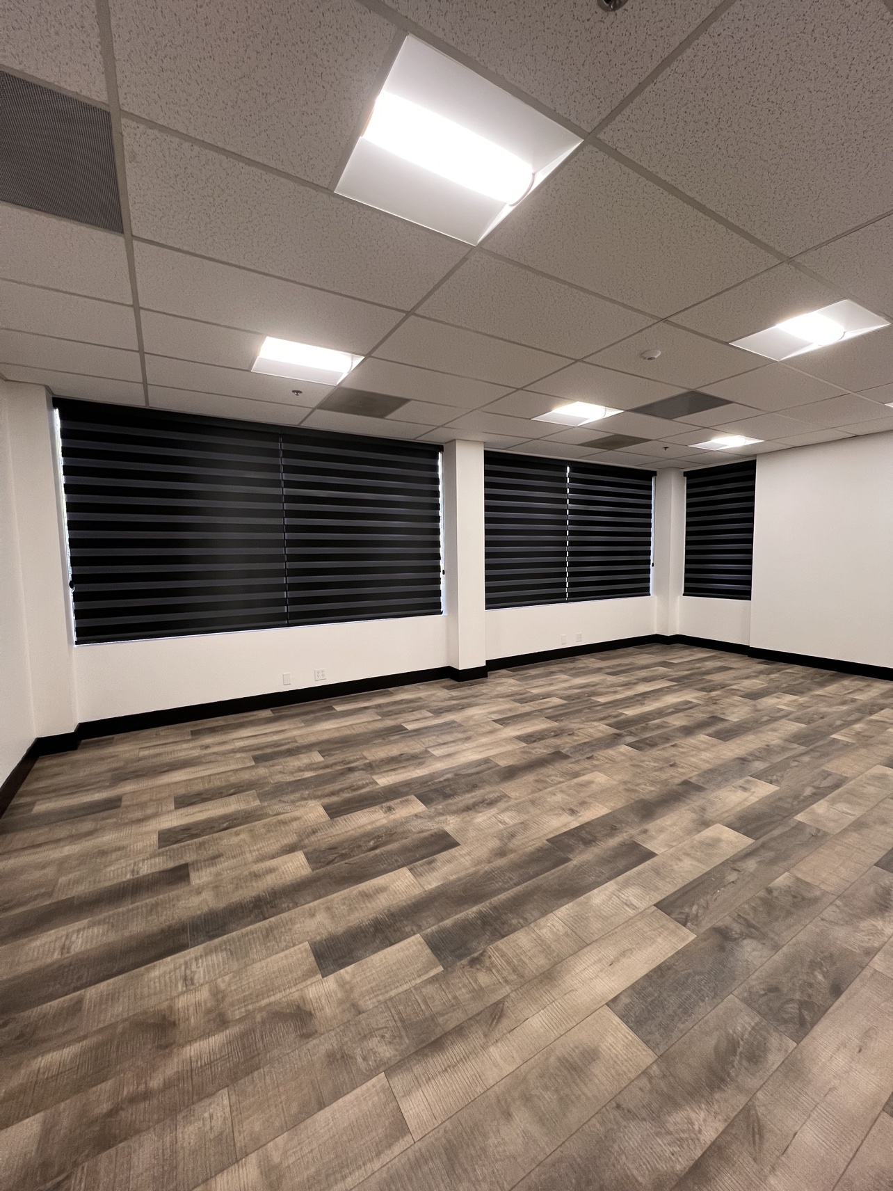 Office suite with blackout zebra bands fully closed across the window wall