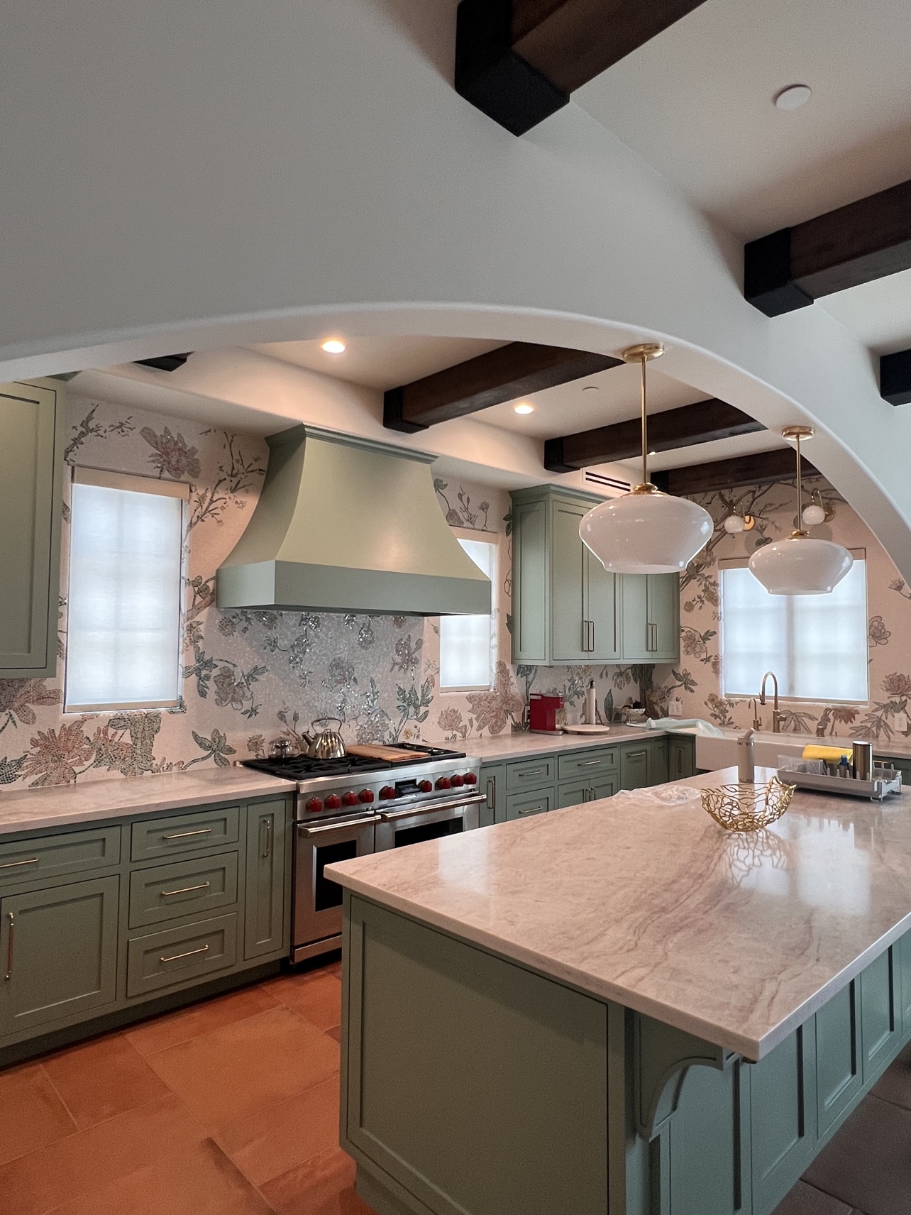 Real ShadeSpot install: white light-filtering roller shades on three windows in a sage-green kitchen
